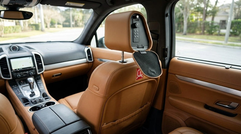 Inside view of a discreet portable gun safe built into a car headrest, showing the open compartment and a digital keypad lock.